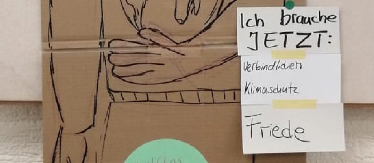 Foto, auf dem Karten mit "Ich brauche JETZT: verbindlichen Klimaschutz und Friede" zu sehen sind.