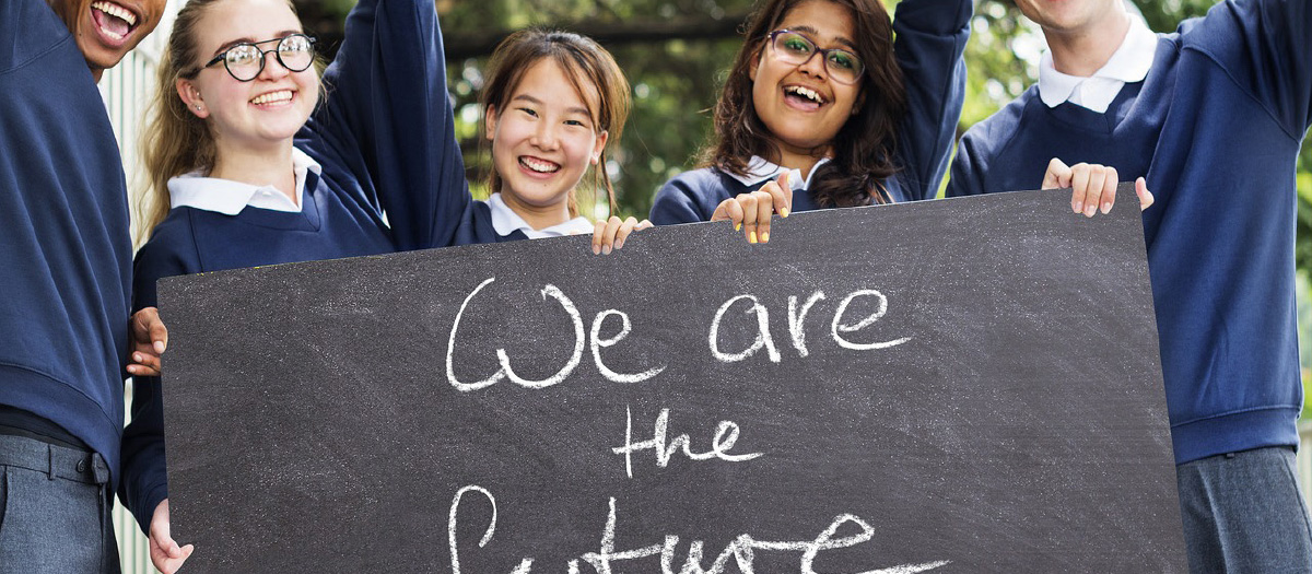 Gruppe von Kindern, die ein Schild mit der Aufschrift "We are the future" in die Kamera hält